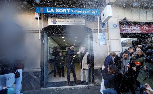 El dueño de la administración de lotería de la calle Travessera de Gràcia muestra su alelgría tras haber vendido integramente el primer premio del sorteo extraordinario de El Niño que ha recaído en el número 37.142 dotado con dos millones de euros por serie (200.000 euros al décimo).