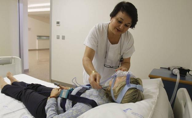 Una trabajadora de la unidad del sueño del hospital Santa Lucía atiende a una paciente.