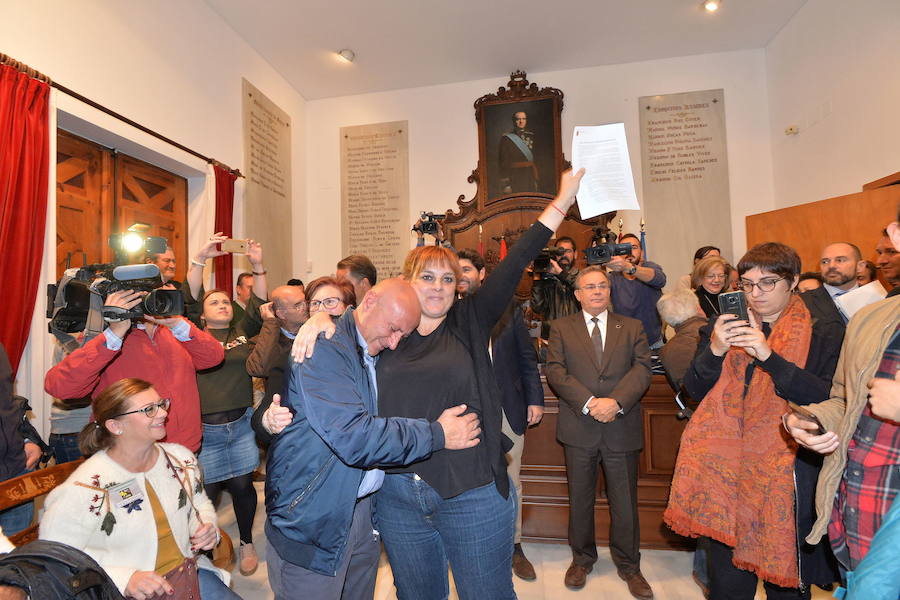 30/10/2018. Los afectados por la devolución de las ayudas de los terremotos abandonan su encierro en el Ayuntamiento de Lorca después de rubricar un acuerdo con el Gobierno regional, que se compromete a paralizar las 159 órdenes de embargo. Además, acuerda dar solución y cerrar unos 3.000 expedientes en el plazo de cinco meses. El documento, rubricado por el consejero de Fomento y la portavoz de la plataforma de afectados por la devolución de las ayudas de los terremotos, Gloria Martín, cuenta como testigos con el presidente López Miras y el alcalde Gil Jódar, además de los más de un centenar de damnificados por las ayudas del terremoto que abarrotan la Sala de Cabildos, donde pasan encerrados siete días y seis noches. En la foto, Pedro Sosa se abraza a Gloria Martín, portavoz de la plataforma de los afectados por las ayudas, que muestra el documento firmado por el Gobierno regional. 