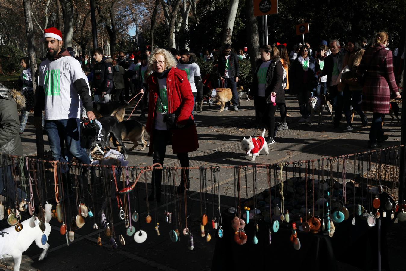 Varias personas con sus perros participan en la octava edición de la Sanperrestre, una iniciativa promovida por la protectora El Refugio que pretende concienciar sobre la importancia de adoptar mascotas en lugar de comprarlas.