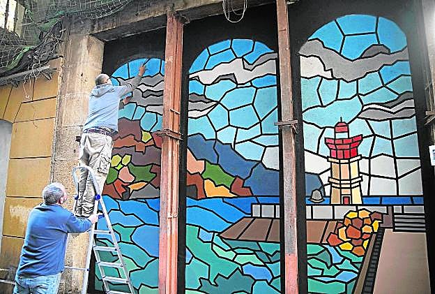Un artista, ultimando su obra de inspiración marítima en un muro de la calle Cuatro Santos. 