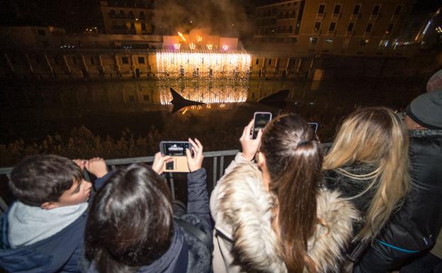 Asistentes al espectáculo de fuego y luces sobre el río graban con sus teléfonos móviles el 'show'. 