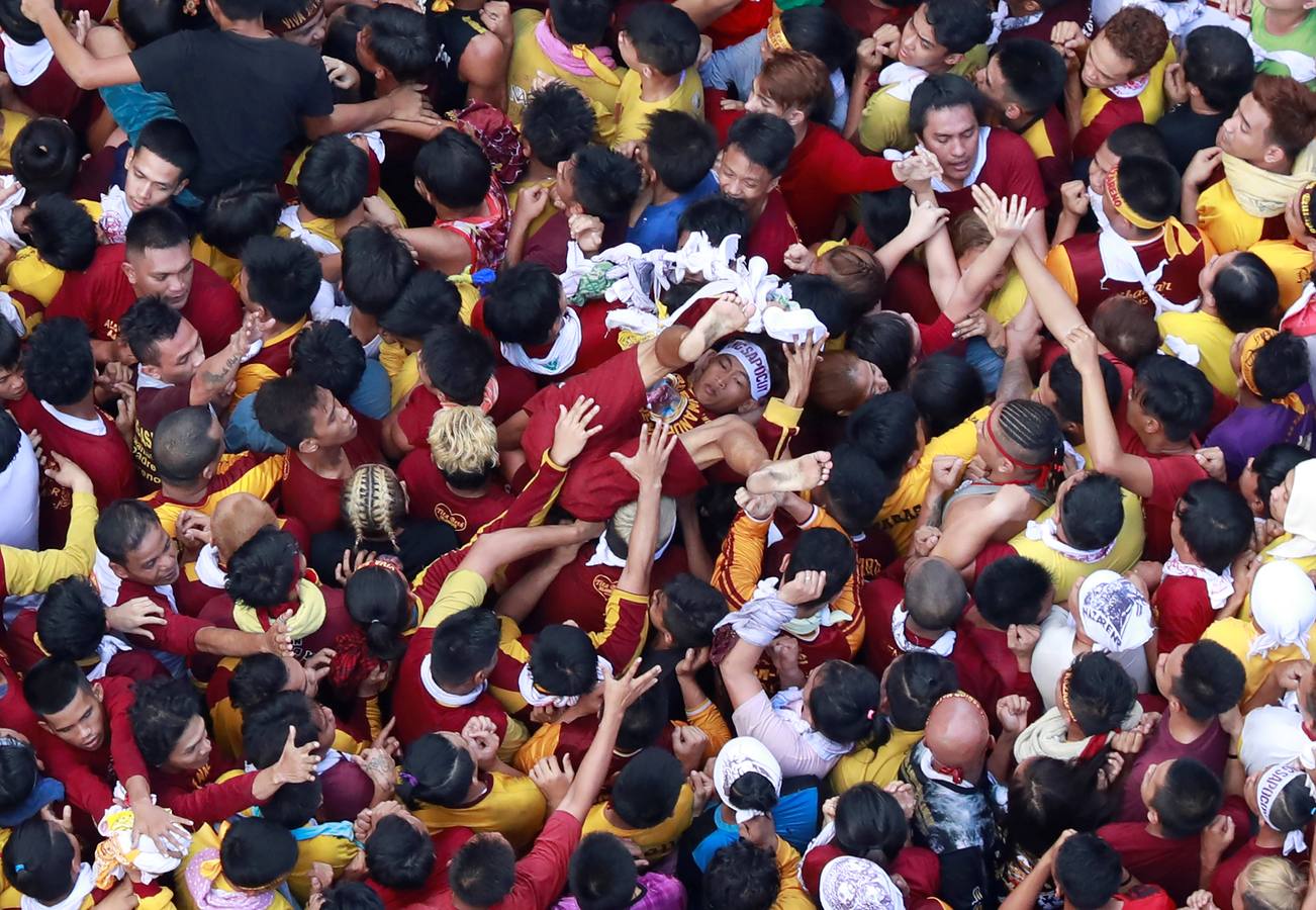 Devotos católicos descalzos empujan durante la procesión en un intento por tocar el Nazareno Negro, una estatua centenaria de un Jesucristo sufriente. Se dice que la estatua de madera de tamaño natural fue traída a Manila (Filipinas), por un sacerdote español.