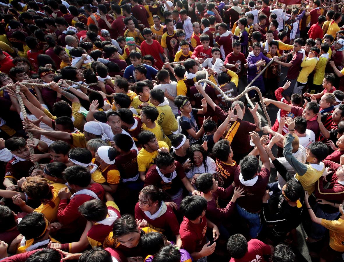 Devotos católicos descalzos empujan durante la procesión en un intento por tocar el Nazareno Negro, una estatua centenaria de un Jesucristo sufriente. Se dice que la estatua de madera de tamaño natural fue traída a Manila (Filipinas), por un sacerdote español.