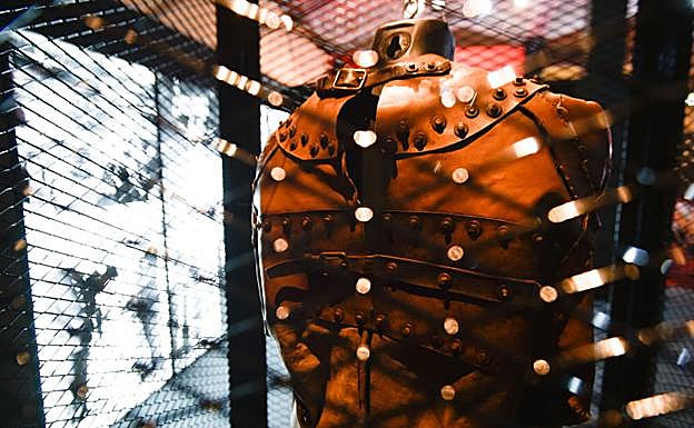 Imagen principal - Una de las réplicas de una camisa de fuerza que utilizó el ilusionista nacido en Budapest en 1874. | Panorámica de la exposición en Murcia, donde juegan un papel fundamental los colores rojo y negro. | Houdini intentó desmontar a los creyentes en el espiritismo como el detective Sherlock Holmes, personaje creado en 1887 por el escritor escocés Arthur Conan Doyle, a quien perdió como amigo.