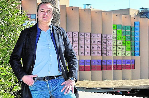 Daniel Torregrosa, con la tabla periódica que decora la Facultad de Química de la Universidad de Murcia a su espalda. 