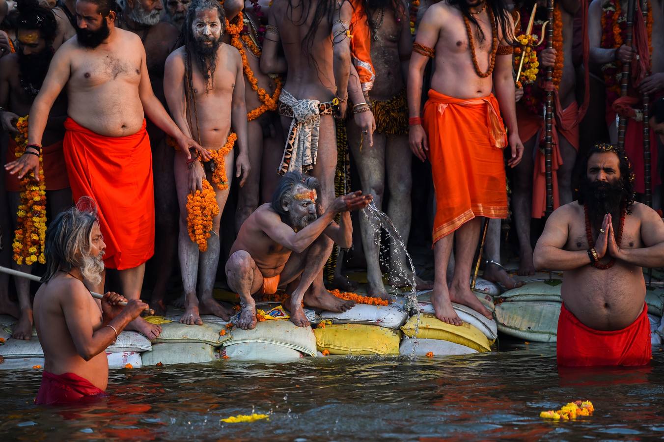 Sadhus (santos desnudos) se bañan en las aguas del río Yamuna, donde confluyen tres de los ríos más sagrados en la mitología hindú: Ganges, Yamuna y Saraswati, durante la celebración del festival Kumbh Mela, en Allahabad, Uttar Pradesh (la India).