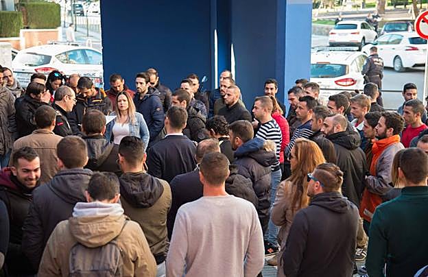 Aspirantes a policías locales aguardan, ayer, en la puerta de la piscina municipal para ser nombrados y tallarse, en la primera prueba de la oposición. 