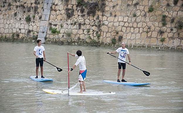 Varios jóvenes practican pádel surf en el río Segura en una imagen de archivo. 