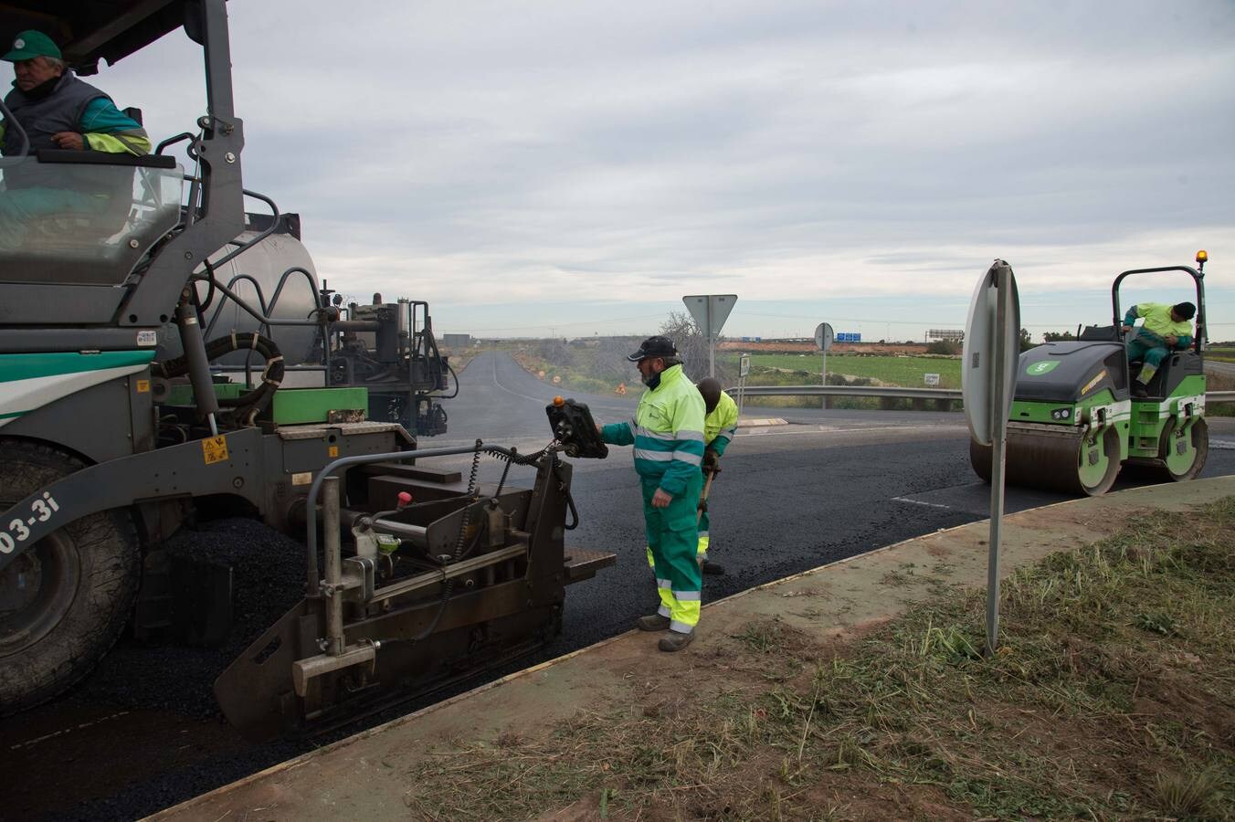 Un grupo de operarios asfalta la rotonda de acceso al polígono industrial Los Camachos, después de hacer lo mismo con la carretera RM-F39, lateral a la futura ZAL.