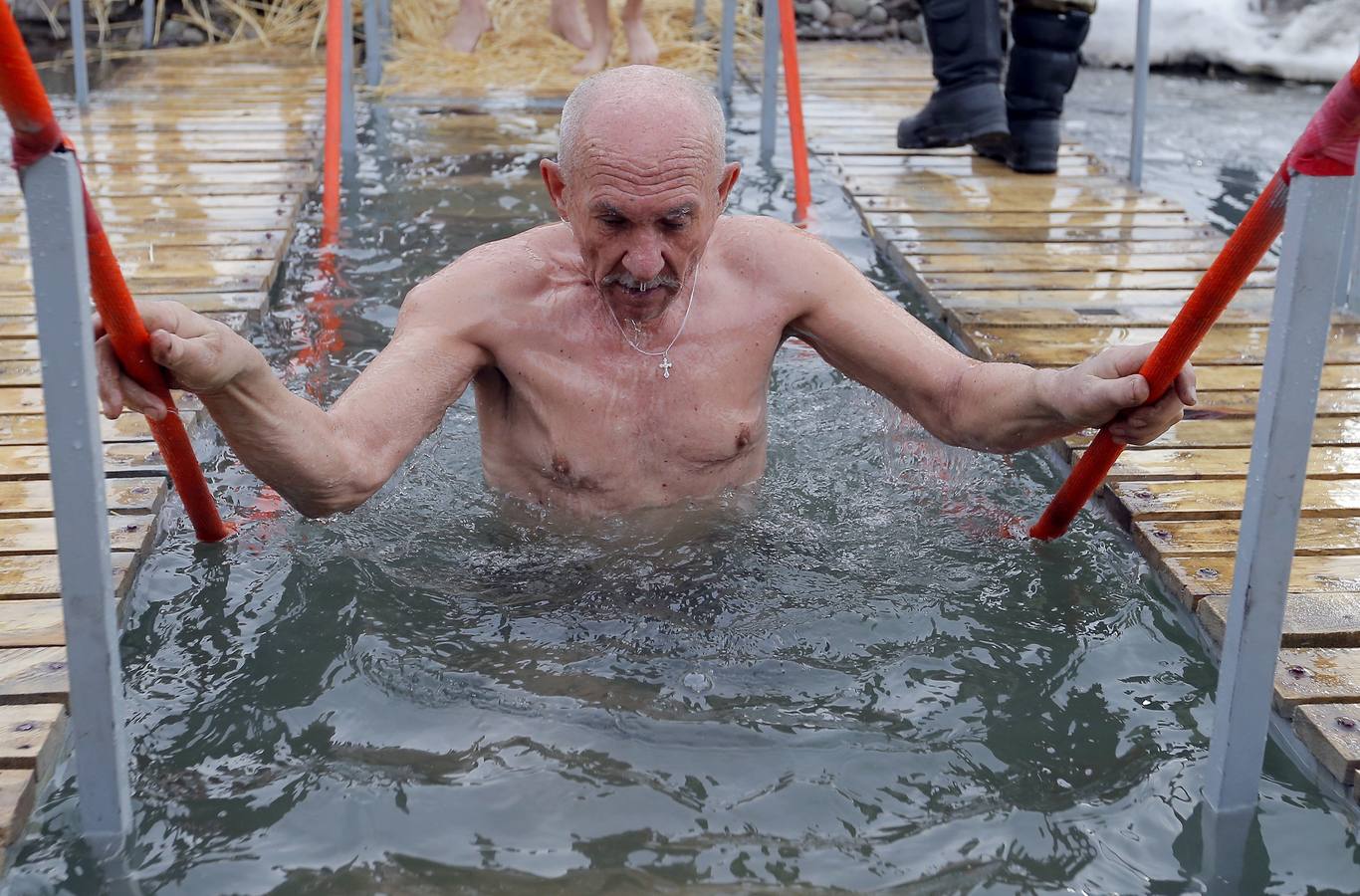 Varias personas se dan un baño en las aguas heladas de un lago para celebrar la Epifanía, cerca de la localidad de Vorontsovka, Biskek (Kirguistán). Los fieles creen que darse un chapuzón en aguas bendecidas fortalece cuerpo y espíritu.
