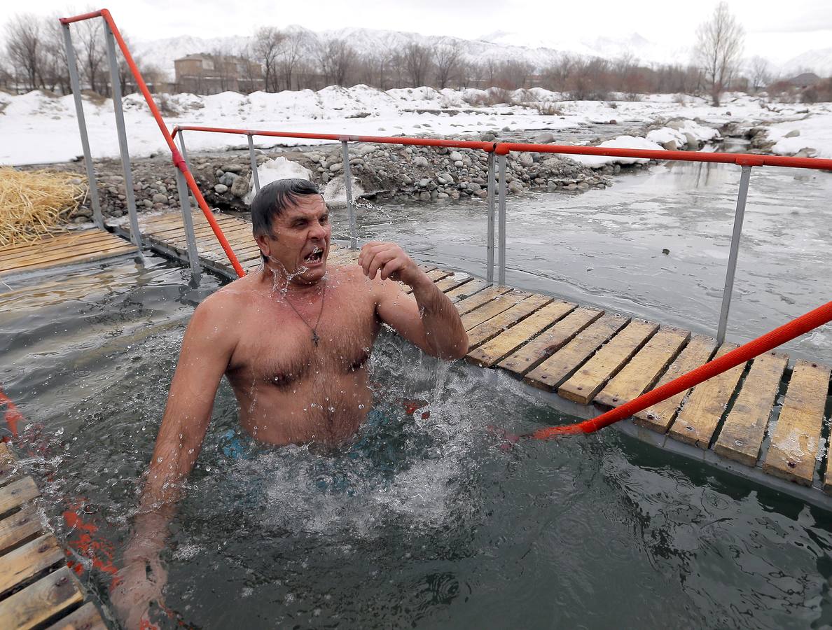 Varias personas se dan un baño en las aguas heladas de un lago para celebrar la Epifanía, cerca de la localidad de Vorontsovka, Biskek (Kirguistán). Los fieles creen que darse un chapuzón en aguas bendecidas fortalece cuerpo y espíritu.