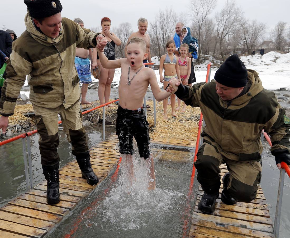 Varias personas se dan un baño en las aguas heladas de un lago para celebrar la Epifanía, cerca de la localidad de Vorontsovka, Biskek (Kirguistán). Los fieles creen que darse un chapuzón en aguas bendecidas fortalece cuerpo y espíritu.