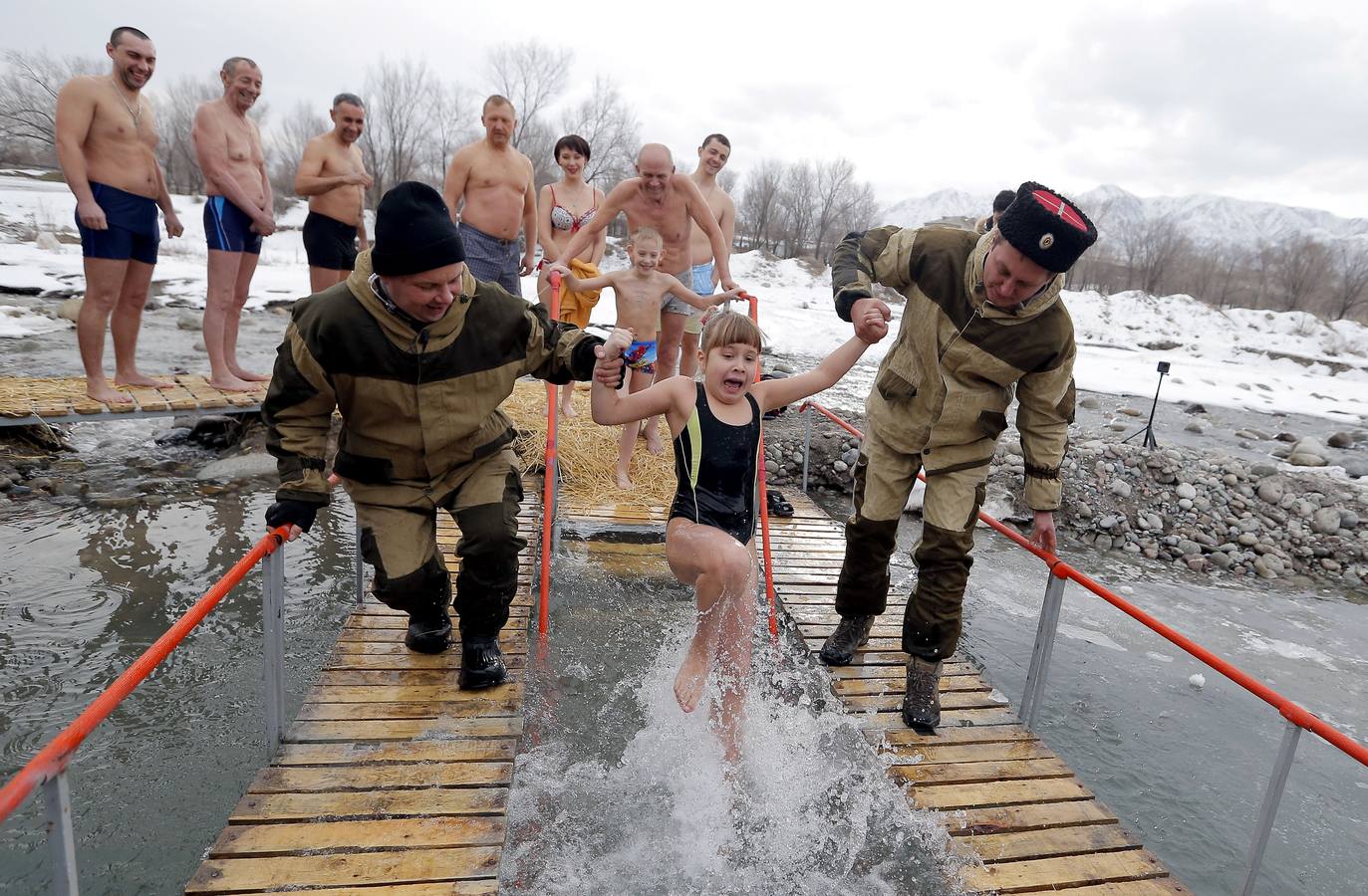 Varias personas se dan un baño en las aguas heladas de un lago para celebrar la Epifanía, cerca de la localidad de Vorontsovka, Biskek (Kirguistán). Los fieles creen que darse un chapuzón en aguas bendecidas fortalece cuerpo y espíritu.