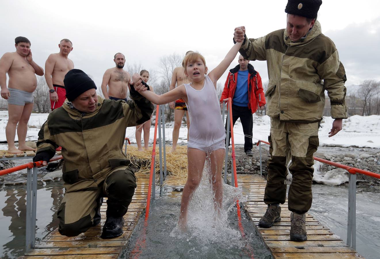 Varias personas se dan un baño en las aguas heladas de un lago para celebrar la Epifanía, cerca de la localidad de Vorontsovka, Biskek (Kirguistán). Los fieles creen que darse un chapuzón en aguas bendecidas fortalece cuerpo y espíritu.