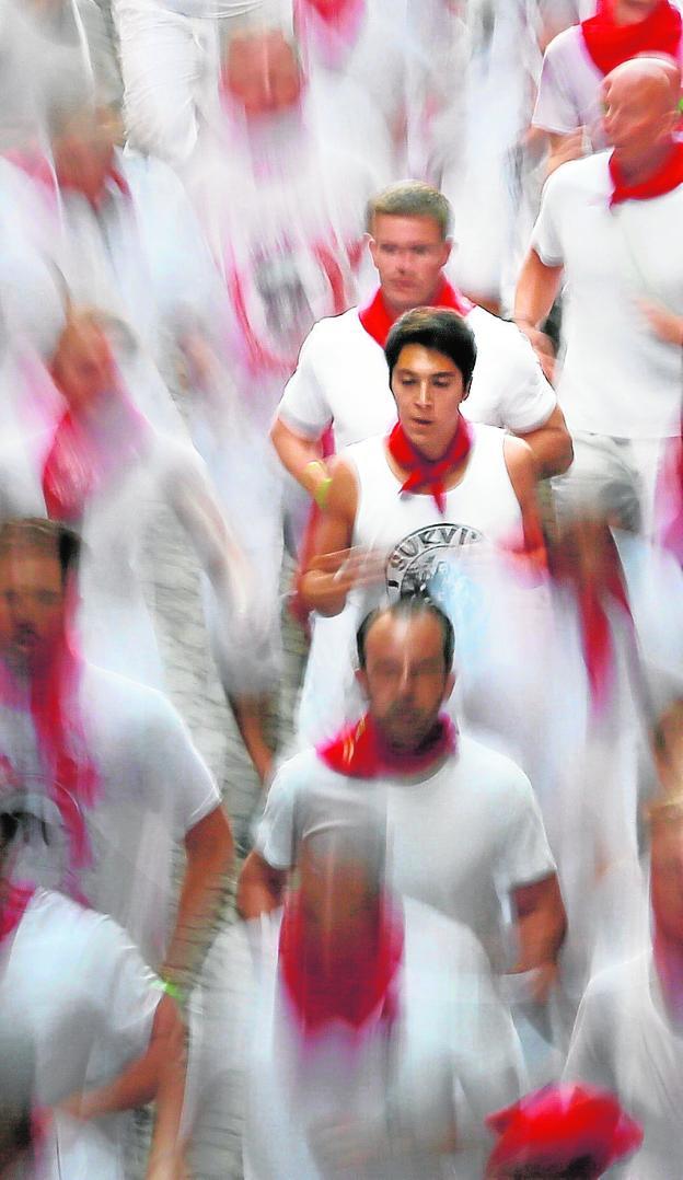 Mozos corriendo un encierro de Sanfermines. 