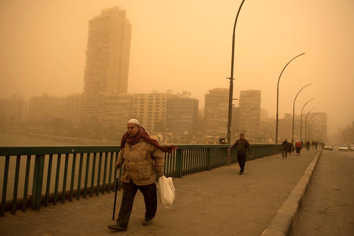 Varias personas se cubren el rostro durante una tormenta de arena en El Cairo, Egipto. La tormenta provocó que varios zoos y parques tuvieran que cerrar sus puertas al público.