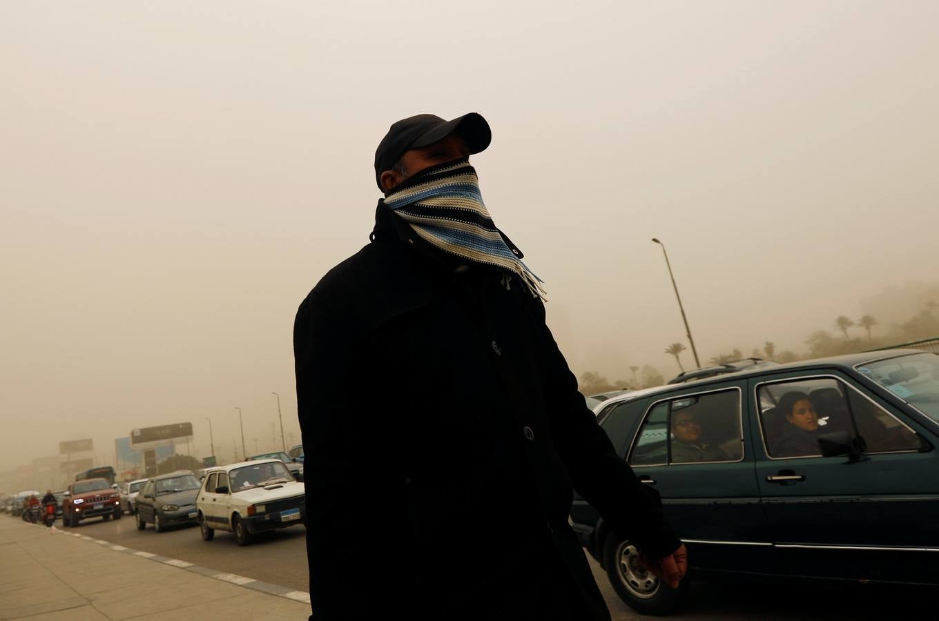 Varias personas se cubren el rostro durante una tormenta de arena en El Cairo, Egipto. La tormenta provocó que varios zoos y parques tuvieran que cerrar sus puertas al público.