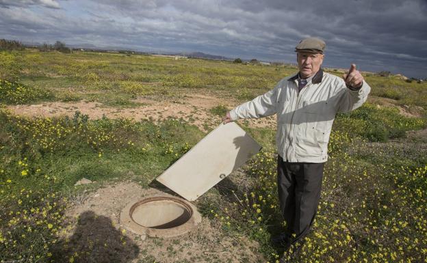 José Martínez tapa con una madera un pozo.