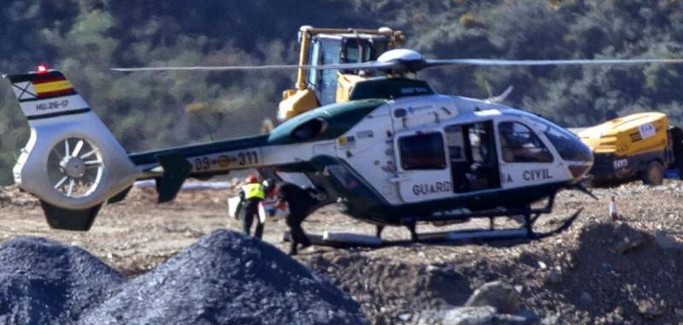 Imagen principal - El helicóptero de la Guardia Civil regresa de Sevilla a Totalán, adonde había acudido para hacer acopio de explosivos para microvoladuras. Segunda imagen: descarga de los explosivos. Tercera foto: las máquinas en la zona de rescate, esta mañana.