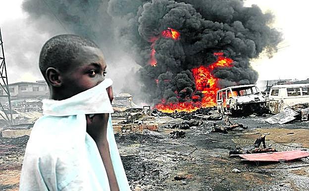 Un joven contempla los cuerpos calcinados tras la explosión ocurrida en Lagos en 2006.