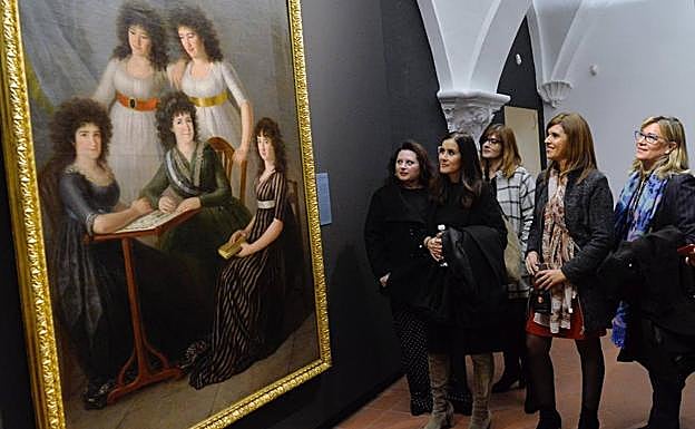 Un grupo de mujeres observa un cuadro de la exposición.