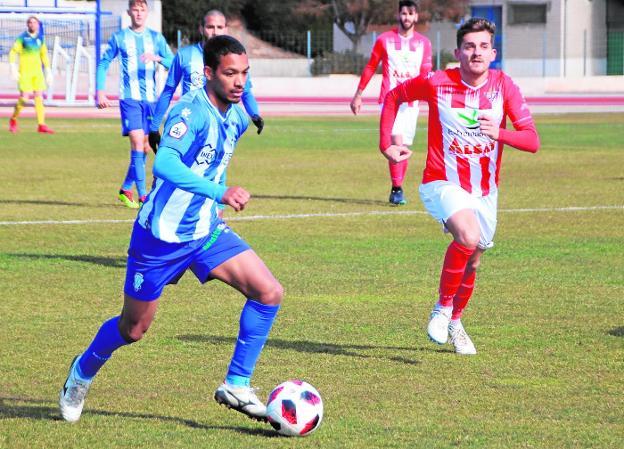 Bouba, del Jumilla, conduce el balón perseguido por Abraham Pozo. 