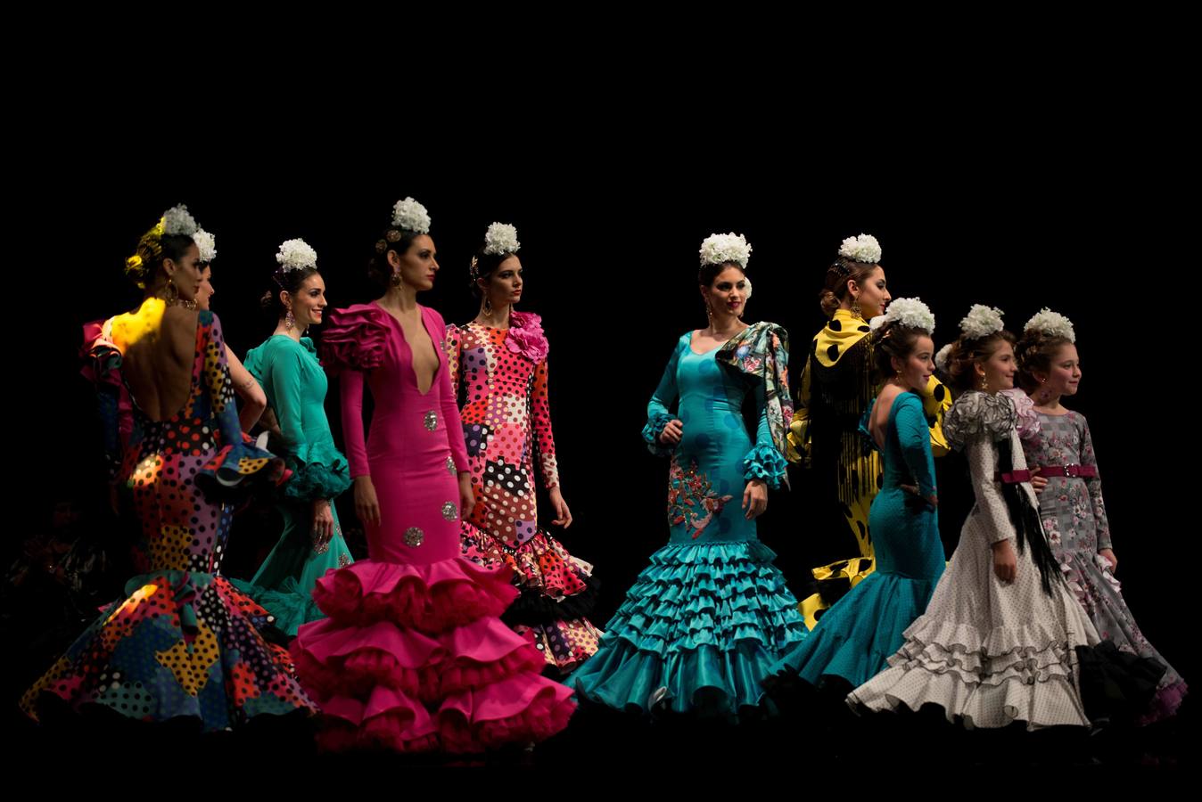 Varias modelos desfilan dentro del salón internacional de moda flamenca SIMOF, en Sevilla, que este año celebra su 25 aniversario.