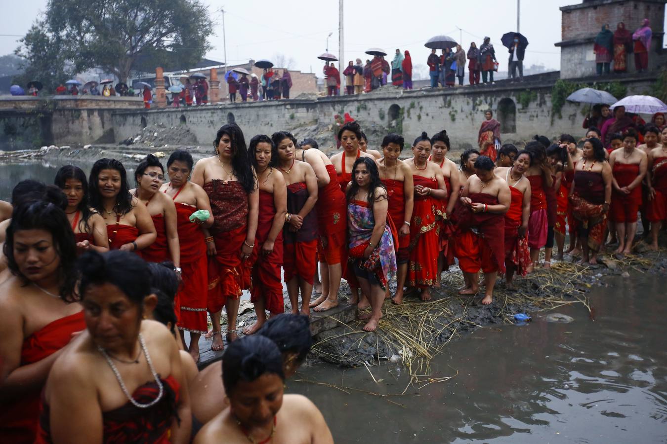 Devotos toman un baño sagrado en el río Hanumante durante el último día del Festival Madhav Narayan en Bhaktapur (Nepal). El Madhay Narayan se celebra durante un mes completo en el que se toman baños sagrados para lavar los pecados y se estudia el libro Swasthani. La veneración a la diosa Swasthani, una festividad que solo se conmemora en Nepal, es única en cada pueblo, con celebraciones y tradiciones diferentes.