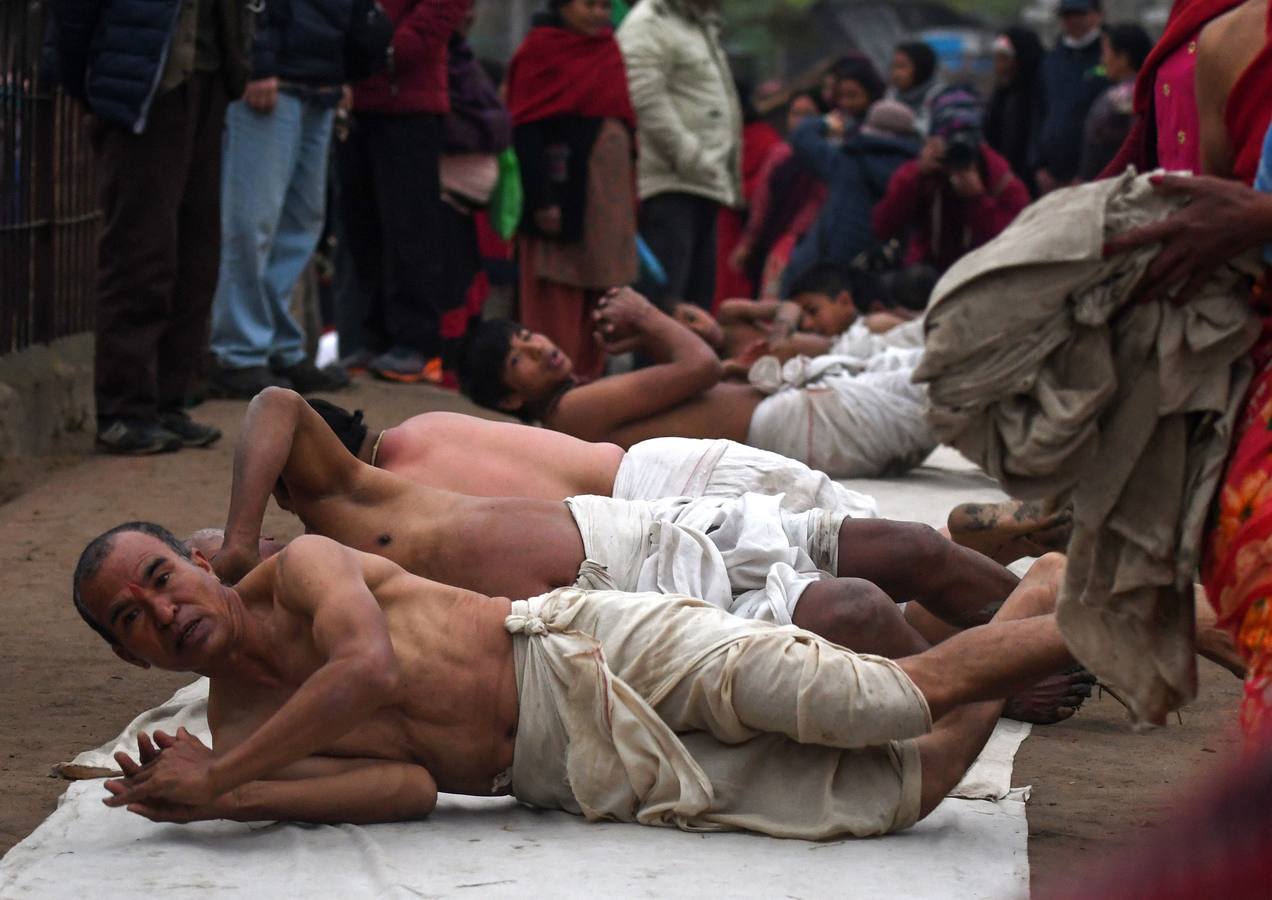 Devotos toman un baño sagrado en el río Hanumante durante el último día del Festival Madhav Narayan en Bhaktapur (Nepal). El Madhay Narayan se celebra durante un mes completo en el que se toman baños sagrados para lavar los pecados y se estudia el libro Swasthani. La veneración a la diosa Swasthani, una festividad que solo se conmemora en Nepal, es única en cada pueblo, con celebraciones y tradiciones diferentes.