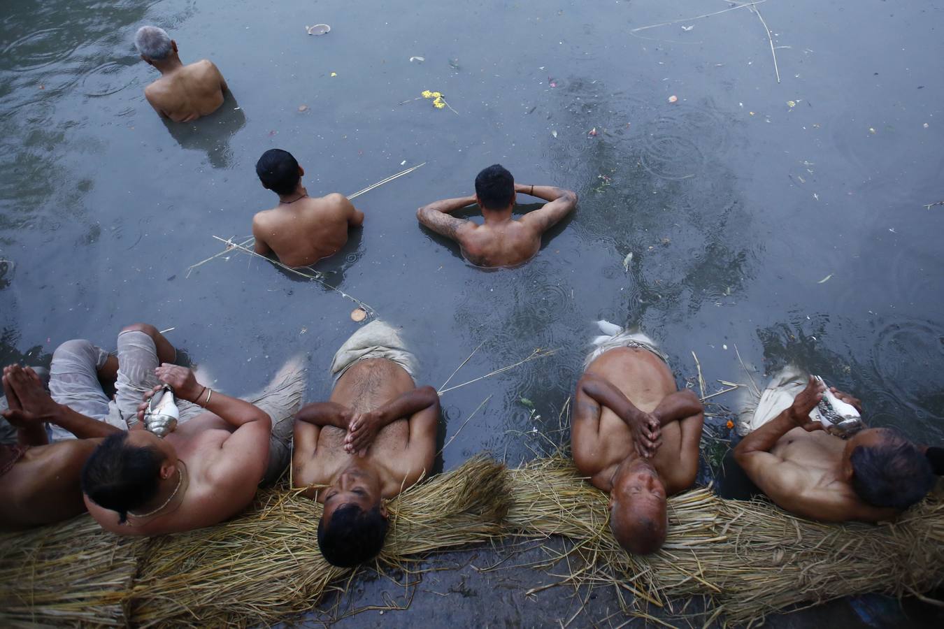 Devotos toman un baño sagrado en el río Hanumante durante el último día del Festival Madhav Narayan en Bhaktapur (Nepal). El Madhay Narayan se celebra durante un mes completo en el que se toman baños sagrados para lavar los pecados y se estudia el libro Swasthani. La veneración a la diosa Swasthani, una festividad que solo se conmemora en Nepal, es única en cada pueblo, con celebraciones y tradiciones diferentes.