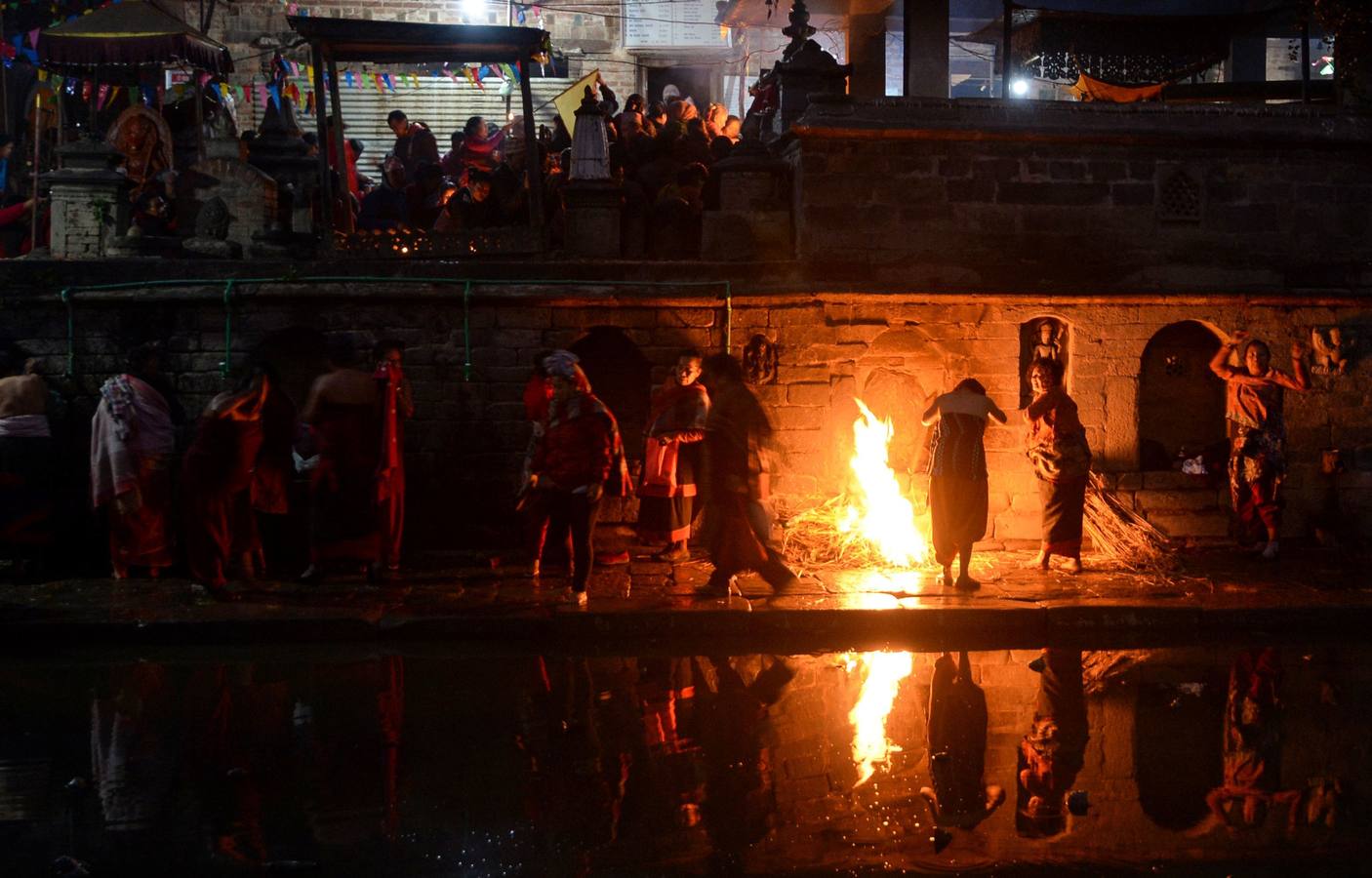 Devotos toman un baño sagrado en el río Hanumante durante el último día del Festival Madhav Narayan en Bhaktapur (Nepal). El Madhay Narayan se celebra durante un mes completo en el que se toman baños sagrados para lavar los pecados y se estudia el libro Swasthani. La veneración a la diosa Swasthani, una festividad que solo se conmemora en Nepal, es única en cada pueblo, con celebraciones y tradiciones diferentes.