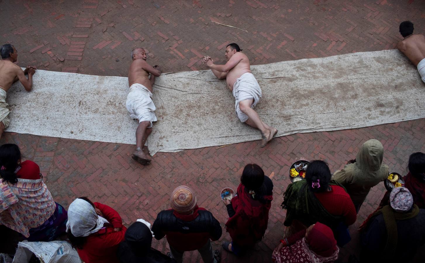 Devotos toman un baño sagrado en el río Hanumante durante el último día del Festival Madhav Narayan en Bhaktapur (Nepal). El Madhay Narayan se celebra durante un mes completo en el que se toman baños sagrados para lavar los pecados y se estudia el libro Swasthani. La veneración a la diosa Swasthani, una festividad que solo se conmemora en Nepal, es única en cada pueblo, con celebraciones y tradiciones diferentes.