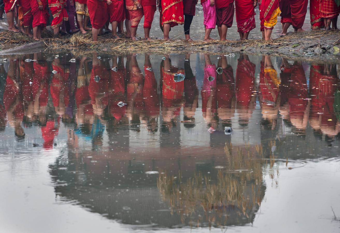 Devotos toman un baño sagrado en el río Hanumante durante el último día del Festival Madhav Narayan en Bhaktapur (Nepal). El Madhay Narayan se celebra durante un mes completo en el que se toman baños sagrados para lavar los pecados y se estudia el libro Swasthani. La veneración a la diosa Swasthani, una festividad que solo se conmemora en Nepal, es única en cada pueblo, con celebraciones y tradiciones diferentes.