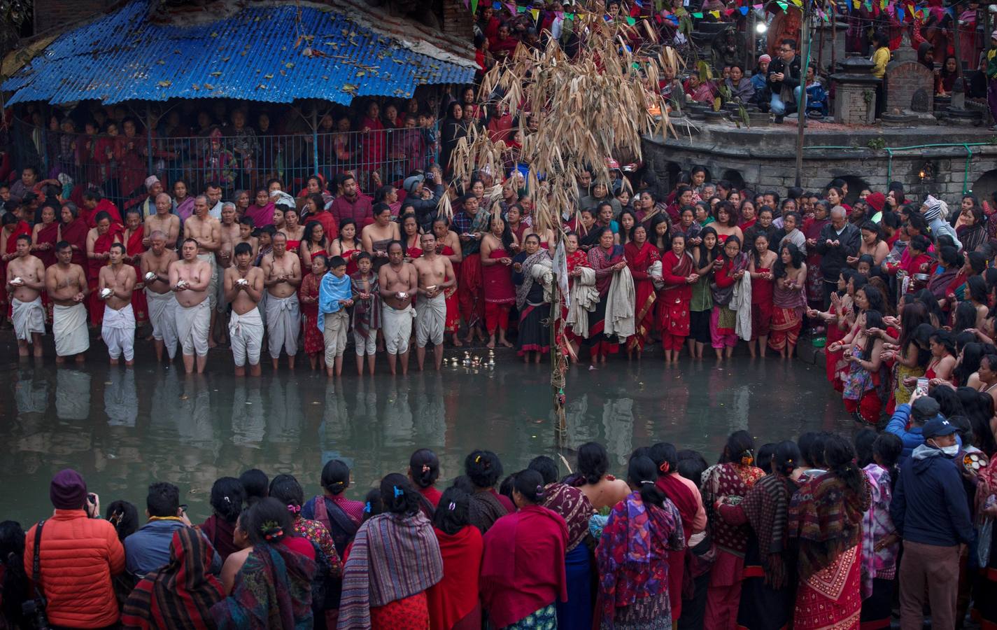 Devotos toman un baño sagrado en el río Hanumante durante el último día del Festival Madhav Narayan en Bhaktapur (Nepal). El Madhay Narayan se celebra durante un mes completo en el que se toman baños sagrados para lavar los pecados y se estudia el libro Swasthani. La veneración a la diosa Swasthani, una festividad que solo se conmemora en Nepal, es única en cada pueblo, con celebraciones y tradiciones diferentes.