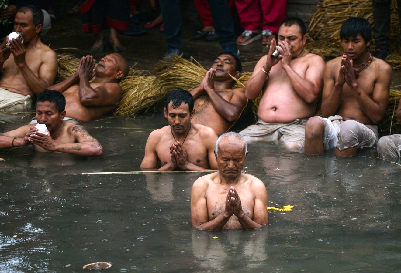 Devotos toman un baño sagrado en el río Hanumante durante el último día del Festival Madhav Narayan en Bhaktapur (Nepal). El Madhay Narayan se celebra durante un mes completo en el que se toman baños sagrados para lavar los pecados y se estudia el libro Swasthani. La veneración a la diosa Swasthani, una festividad que solo se conmemora en Nepal, es única en cada pueblo, con celebraciones y tradiciones diferentes.