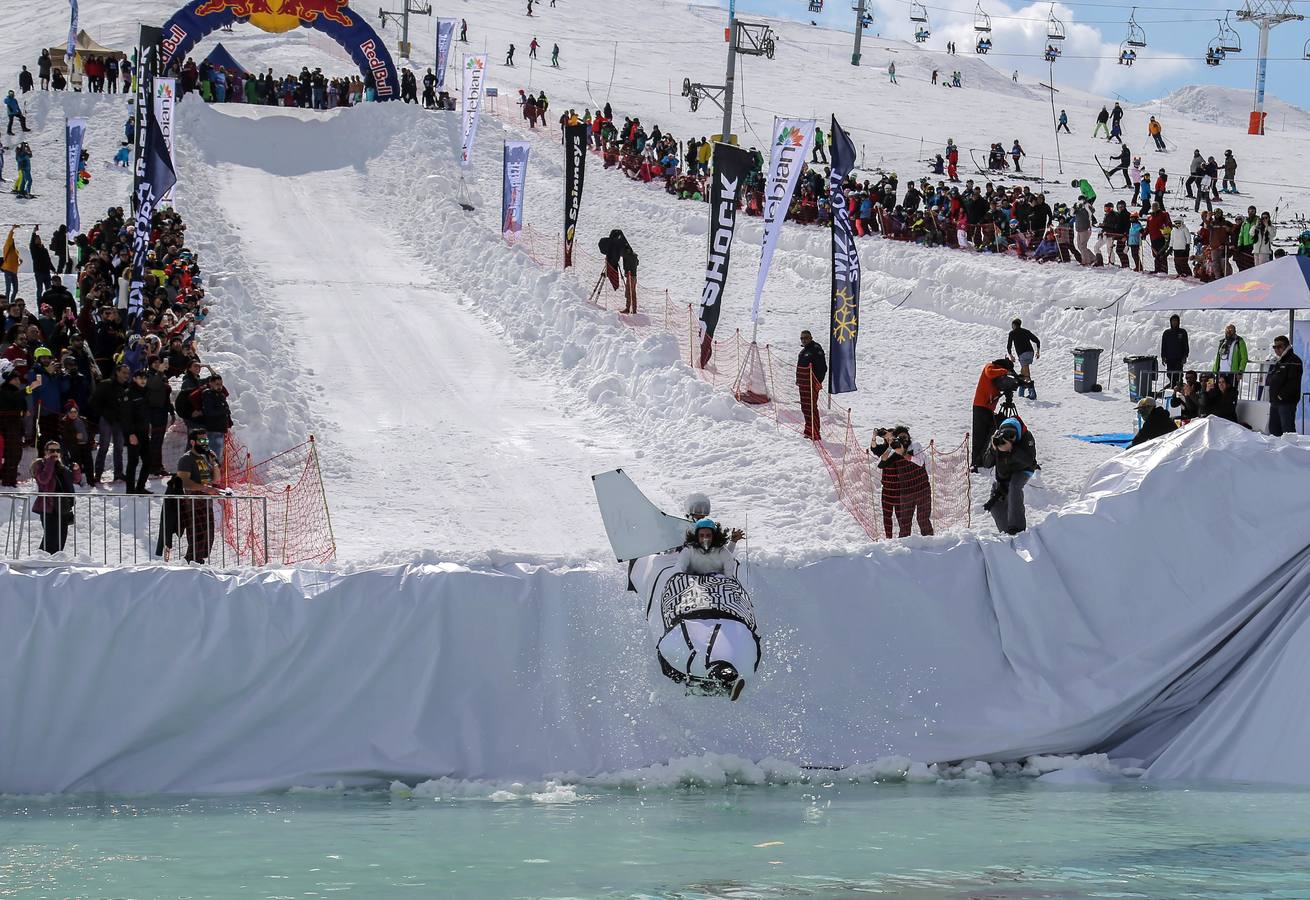 Varios participantes participan en competención Red Bull Jump and Freeze en la estación de esquí Mzaar en Kfardebian Lebanon Mountain, en Kfardebian, Líbano. Los participantes que usan trajes festivos realizan piruetas antes de meterse en un estanque con agua helada. 