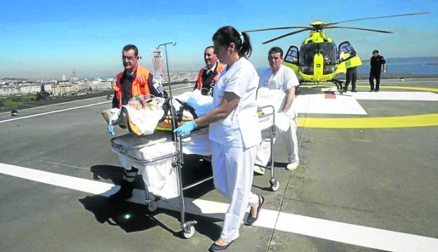 Despliegue de medios. Sanitarios reciben a un paciente trasladado en helicóptero hasta la azotea de un hospital gallego. 