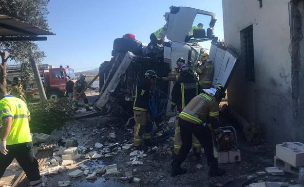 Efectivos de bomberos trabajan en la cabina del camión accidentado. 