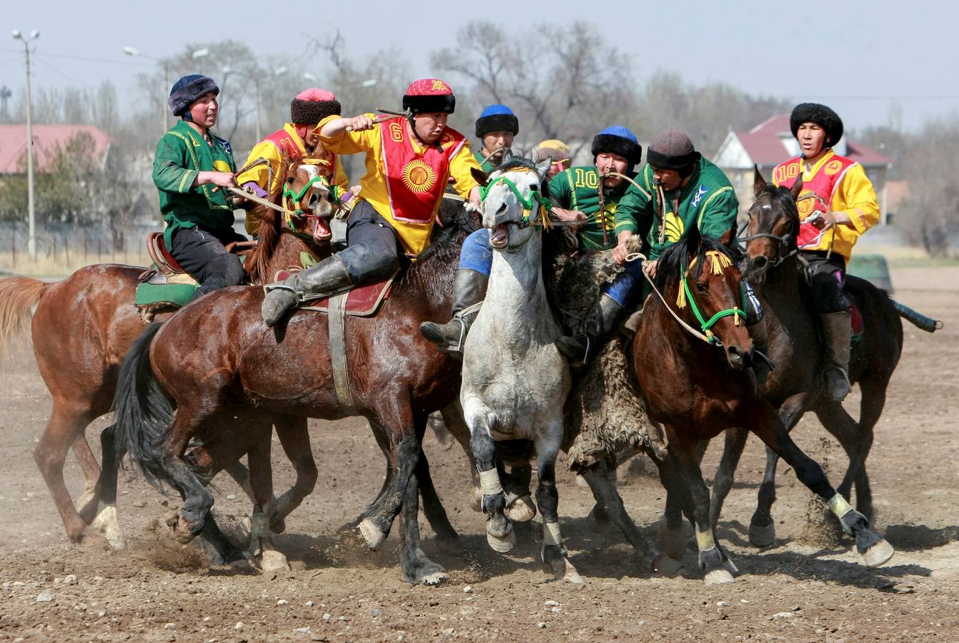 Varios jinetes participan en la competición tradicional kirguizistana llamada 'Kok-Boru', o arrastre de la cabra, con motivo de las celebraciones del Año Nuevo en el calendario solar persa, en Biskek (Kirguizistán). En el Kok-Boru los jugadores deben agarrar el cuerpo de una cabra desde el suelo mientras montan a caballo e intentar anotar un tanto al dejarlo sobre la portería del contrario.