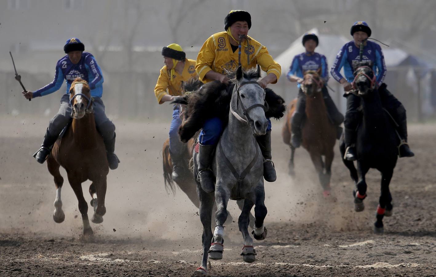 Varios jinetes participan en la competición tradicional kirguizistana llamada 'Kok-Boru', o arrastre de la cabra, con motivo de las celebraciones del Año Nuevo en el calendario solar persa, en Biskek (Kirguizistán). En el Kok-Boru los jugadores deben agarrar el cuerpo de una cabra desde el suelo mientras montan a caballo e intentar anotar un tanto al dejarlo sobre la portería del contrario.