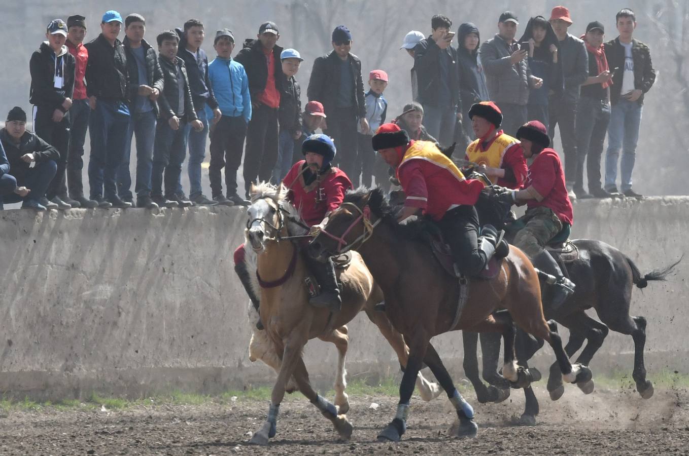 Varios jinetes participan en la competición tradicional kirguizistana llamada 'Kok-Boru', o arrastre de la cabra, con motivo de las celebraciones del Año Nuevo en el calendario solar persa, en Biskek (Kirguizistán). En el Kok-Boru los jugadores deben agarrar el cuerpo de una cabra desde el suelo mientras montan a caballo e intentar anotar un tanto al dejarlo sobre la portería del contrario.