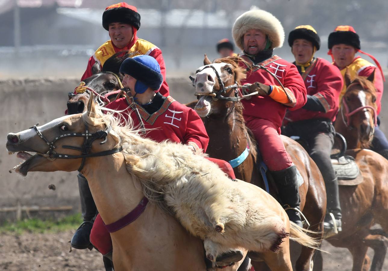 Varios jinetes participan en la competición tradicional kirguizistana llamada 'Kok-Boru', o arrastre de la cabra, con motivo de las celebraciones del Año Nuevo en el calendario solar persa, en Biskek (Kirguizistán). En el Kok-Boru los jugadores deben agarrar el cuerpo de una cabra desde el suelo mientras montan a caballo e intentar anotar un tanto al dejarlo sobre la portería del contrario.