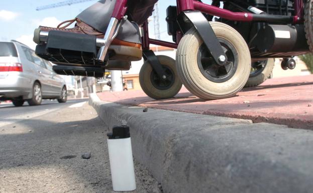 Una persona en silla de ruedas bajando una acera en Murcia, en una foto de archivo.