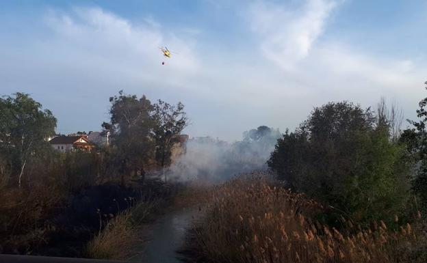 Un helicoptero del Consorcio de Extinción de Incendios controla el fuego.