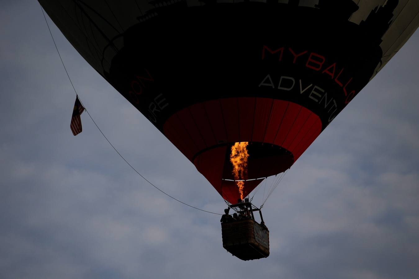 Varias personas asisten a la décima Fiesta Internacional de Globos Aerostáticos de Putrajaya (Malasia). Más de 20 globos aerostáticos volaron por los cielos en la fiesta anual, organizada para promover el turismo y los deportes de aviación. 