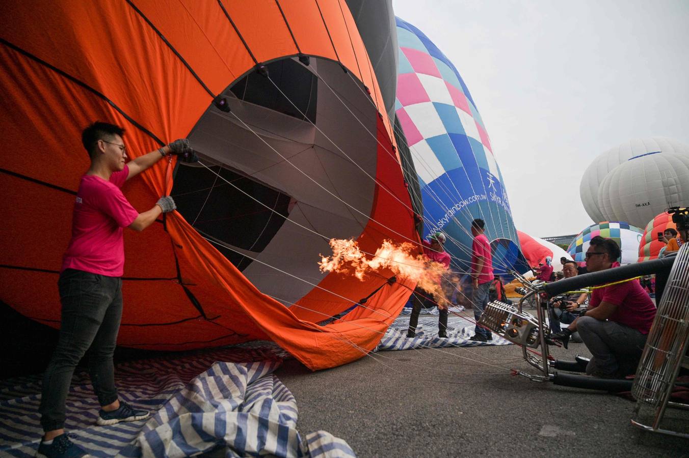 Varias personas asisten a la décima Fiesta Internacional de Globos Aerostáticos de Putrajaya (Malasia). Más de 20 globos aerostáticos volaron por los cielos en la fiesta anual, organizada para promover el turismo y los deportes de aviación. 