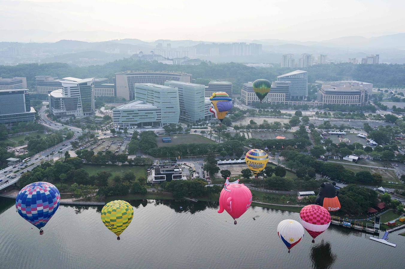 Varias personas asisten a la décima Fiesta Internacional de Globos Aerostáticos de Putrajaya (Malasia). Más de 20 globos aerostáticos volaron por los cielos en la fiesta anual, organizada para promover el turismo y los deportes de aviación. 