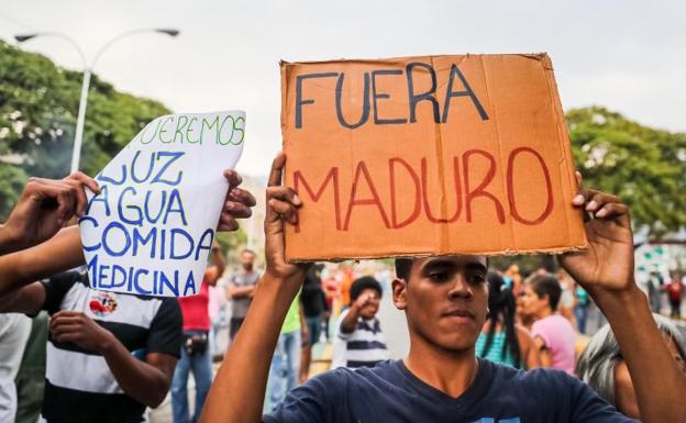 Un grupo de personas protesta por la falta de agua potable y electricidad en el centro de Caracas.