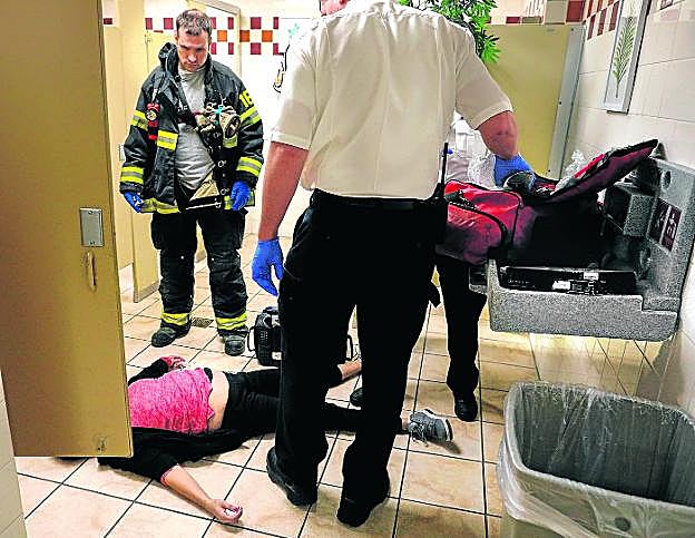 Miles de casos. Los sanitarios atienden a una mujer de 40 años víctima de una sobredosis de opiáceos en el baño de una tienda de Malden (Massachusetts). 